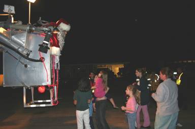 Santa in fire truck ladder